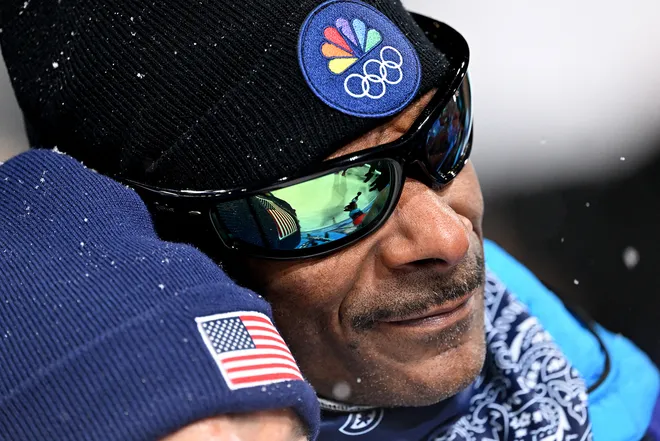 Snoop Dogg attends the Winter Olympics close up with a black beanie and NBC logo