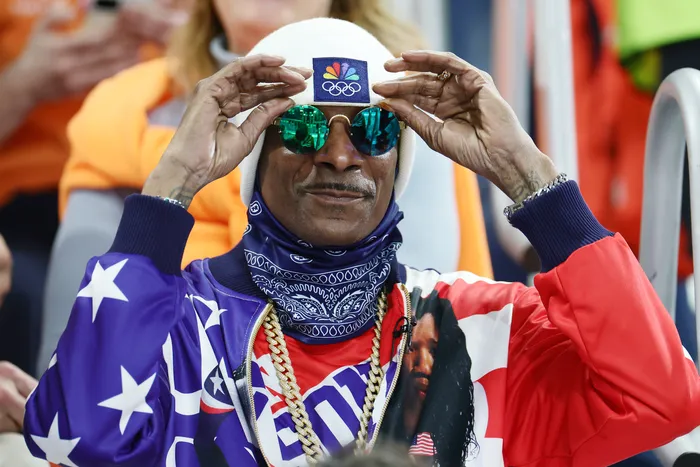 Artist Snoop Dogg with American Flag Jacket and a white NBC beanie at the 2026 Winter Olympics in Cortina Milano